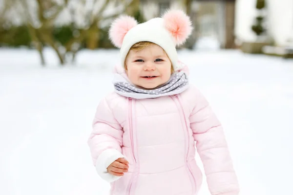 Adorável menina fazendo primeiros passos ao ar livre no inverno. Bonito criança aprendendo a andar. — Fotografia de Stock