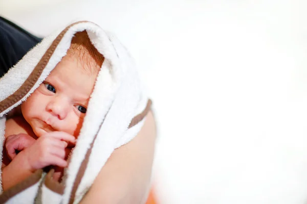 Mutter hält ihre neugeborene Tochter nach der Geburt auf dem Arm. Mutter mit Baby-Mädchen, Liebe. Neugeborenes kuschelt in Mamas Armen und blickt in die Kamera. Bindung, Familie, neues Leben. — Stockfoto