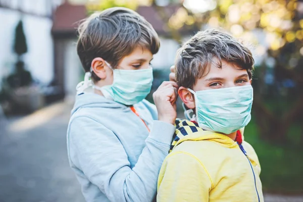 Двоє дітей у медичній масці захищаються від пандемії коронавірусної хвороби. Діти, милі брати і сестри і найкращі друзі використовують захисне обладнання як боротьбу проти ковадла 19 . — стокове фото