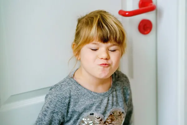 Porträt eines fröhlich lächelnden Kleinkindes im Haus. Kleines Vorschulkind mit blonden Haaren blickt in die Kamera. — Stockfoto