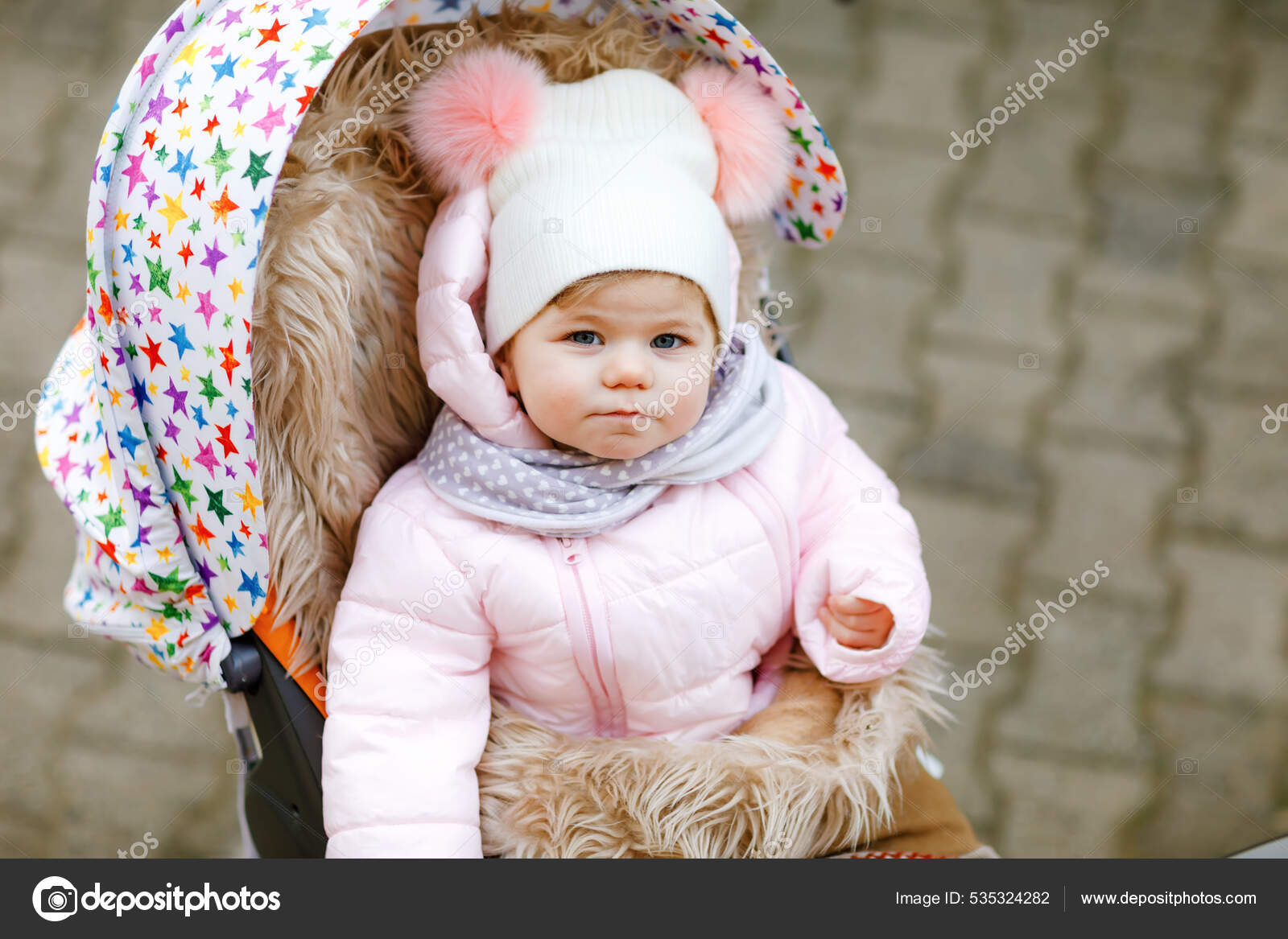 perle Møntvask Terminal Sød lille smuk baby pige sidder i barnevognen eller klapvogn på koldt  efterår, vinter eller forårsdag. Happy smilende barn i varmt tøj, mode  stilfuld baby frakke og hat. Sne falder ned —