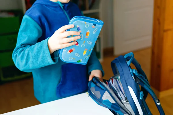 Der Schuljunge bereitet sich morgens auf die Schule vor. Gesunde Kinder füllen Schulranzen mit Büchern, Stiften, Ordnern und Schulsachen. Vorbereitung, Routinekonzept. — Stockfoto