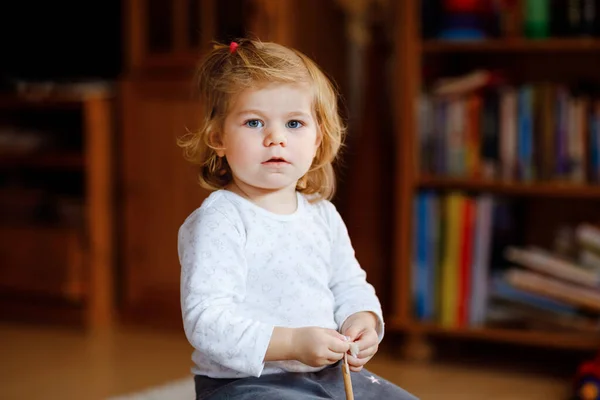 Imádnivaló, aranyos kislány, aki otthon játszik. Boldog egészséges baba gyermek szórakozás különböző játékok. A gyönyörű baba portréja — Stock Fotó