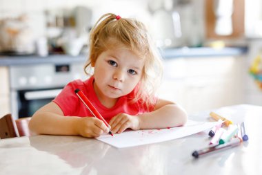 Evinde renkli kalemlerle resim yapan şirin, küçük bir bebek. Sevimli, sağlıklı, keçeli kalemlerle çizim yapmayı öğrenen bir çocuk. Aktif çocuk evde ya da çocuk odasında eğleniyor..