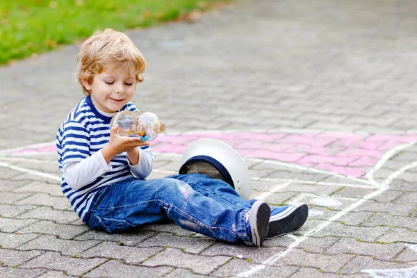 Malý kluk kluk jako pirát na loď nebo sailingboat malby s barevné křídy na asfaltu. Pro děti, venku v létě kreativní odpočinek. Dítě s kapitánem kloboukem a dalekohledy. — Stock fotografie