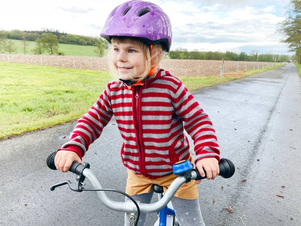 Μικρό κοριτσάκι τρέχει με ποδήλατο ισορροπία την ημέρα του καλοκαιριού. Χαρούμενη παιδική οδήγηση, ποδηλασία με ποδήλατο, υπαίθρια δραστηριότητα. Ευτυχία, παιδική ηλικία — Φωτογραφία Αρχείου
