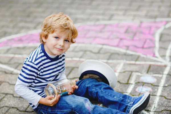 Niño pequeño como pirata en barco o velero cuadro de pintura con tiza de colores sobre asfalto. Ocio creativo para los niños al aire libre en verano. Niño con gorro de capitán y prismáticos . — Foto de Stock