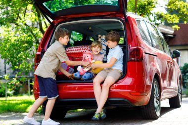 Yaz tatiline çıkmadan önce üç çocuk, iki oğlan ve iki anaokulu öğrencisi arabanın bagajında oturuyor. Mutlu çocuklar, kardeşler, bavulları ve oyuncakları olan kız ve erkek kardeşler yolculuğa çıkıyorlar.