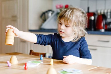 Salon oyunu oynayan sevimli küçük kız. Mutlu sağlıklı çocuk hafızasını eğitiyor, düşünüyor. Salgın Coronavirus covid karantina hastalığı sırasında çocuğun evde dinlenmesi ve eğitilmesi