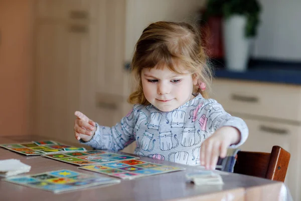 Emocionado sonriente linda niña jugando juego de cartas imagen. Feliz niño sano entrenando la memoria, pensando. Creativo en interiores de ocio y educación de los niños. Actividad familiar en casa. —  Fotos de Stock