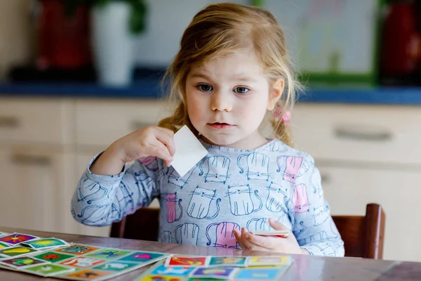 Emocionado sonriente linda niña jugando juego de cartas imagen. Feliz niño sano entrenando la memoria, pensando. Creativo en interiores de ocio y educación de los niños. Actividad familiar en casa. — Foto de Stock