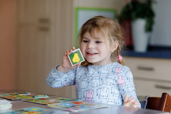 Ενθουσιασμένος χαμογελώντας χαριτωμένο κοριτσάκι παίζει το παιχνίδι καρτών εικόνας. Ευτυχισμένο υγιές παιδί εκπαιδεύει τη μνήμη, τη σκέψη. Δημιουργική εσωτερική αναψυχή και εκπαίδευση του παιδιού. Οικογενειακή δραστηριότητα στο σπίτι. — Φωτογραφία Αρχείου