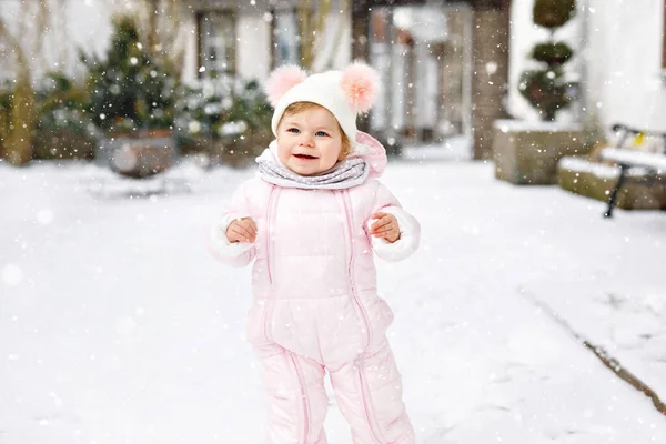 Adorable petite fille qui fait ses premiers pas à l'extérieur en hiver. Bébé mignon apprendre à marcher. — Photo