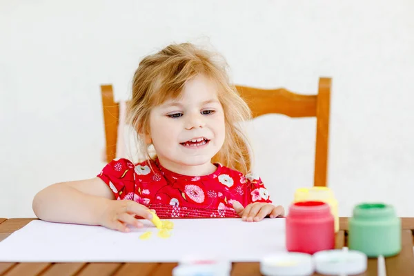 Pequeña niña creativa pintando con los colores de los dedos un pez. Niño activo divirtiéndose con el dibujo en casa, en el kindergaten o preescolar. Educación y aprendizaje a distancia para niños. Actividad creadora. — Foto de Stock