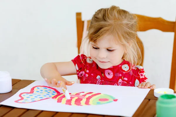 Küçük yaratıcı kız parmak boyasıyla balık boyuyor. Aktif çocuk evde çizim yaparken eğleniyor, anaokulunda ya da anaokulunda. Çocuklar için eğitim ve uzak mesafe eğitimi. Creaitve etkinliği. — Stok fotoğraf