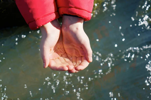 Nehirden gelen suyu olan bir çocuğun elleri. Su yardımı, dünya konsepti. — Stok fotoğraf