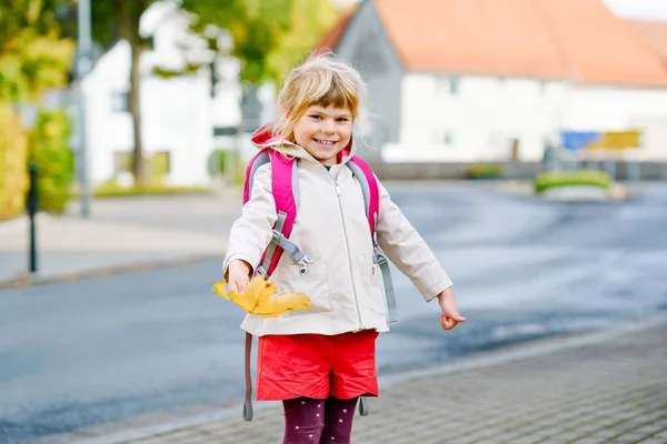Okuldaki ilk gününde tatlı küçük bir anaokulu kızı. Sağlıklı, mutlu bir çocuk anaokuluna gidiyor. Sırt çantalı çocuk şehir sokaklarında kreşe gidiyor. — Stok fotoğraf