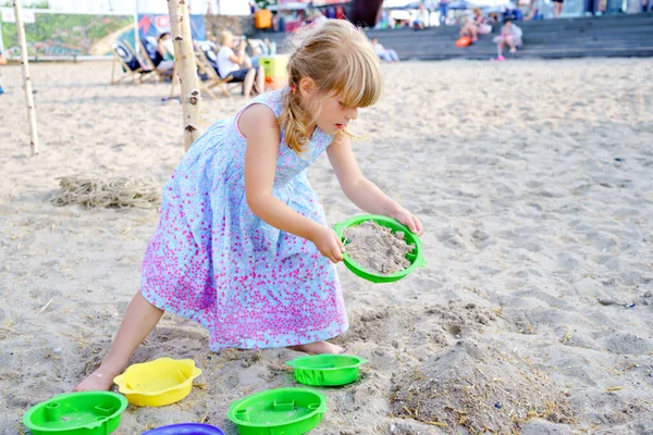 Niña preescolar jugando con juguetes de arena en la playa. Lindo niño feliz en vacaciones familiares en el mar. Niño activo teniendo fung en el Mar Báltico. Actividad al aire libre para niños — Foto de Stock