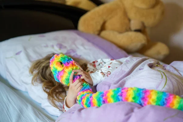 Carino piccola ragazza in età prescolare dopo aver dormito a letto. Felice gioioso bambino sorridente svegliarsi al mattino, sonno sano dei bambini di giorno — Foto Stock