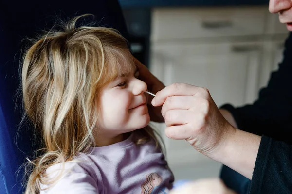 Padre che fa diventare il virus della corona nasale una bambina, un bambino in età prescolare. Figlia e papà prendono covid test antigene a casa con tampone di cotone. — Foto Stock