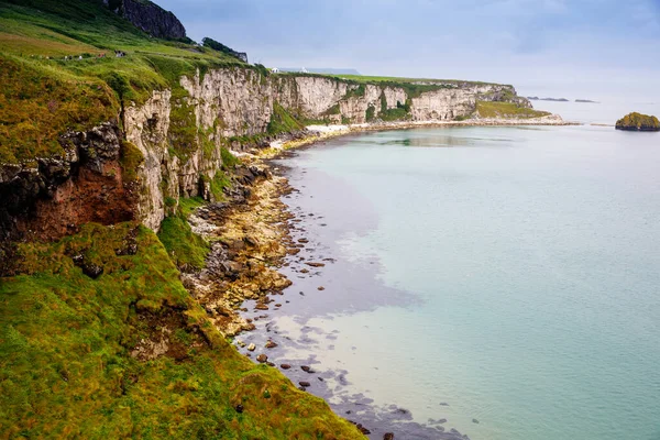 Wybrzeże w pobliżu Carrick-a-Rede Rope Bridge, słynny most linowy w pobliżu Ballintoy w hrabstwie Antrim, Irlandia Północna na irlandzkim wybrzeżu. Dziki Atlantyk w pochmurny dzień. — Zdjęcie stockowe