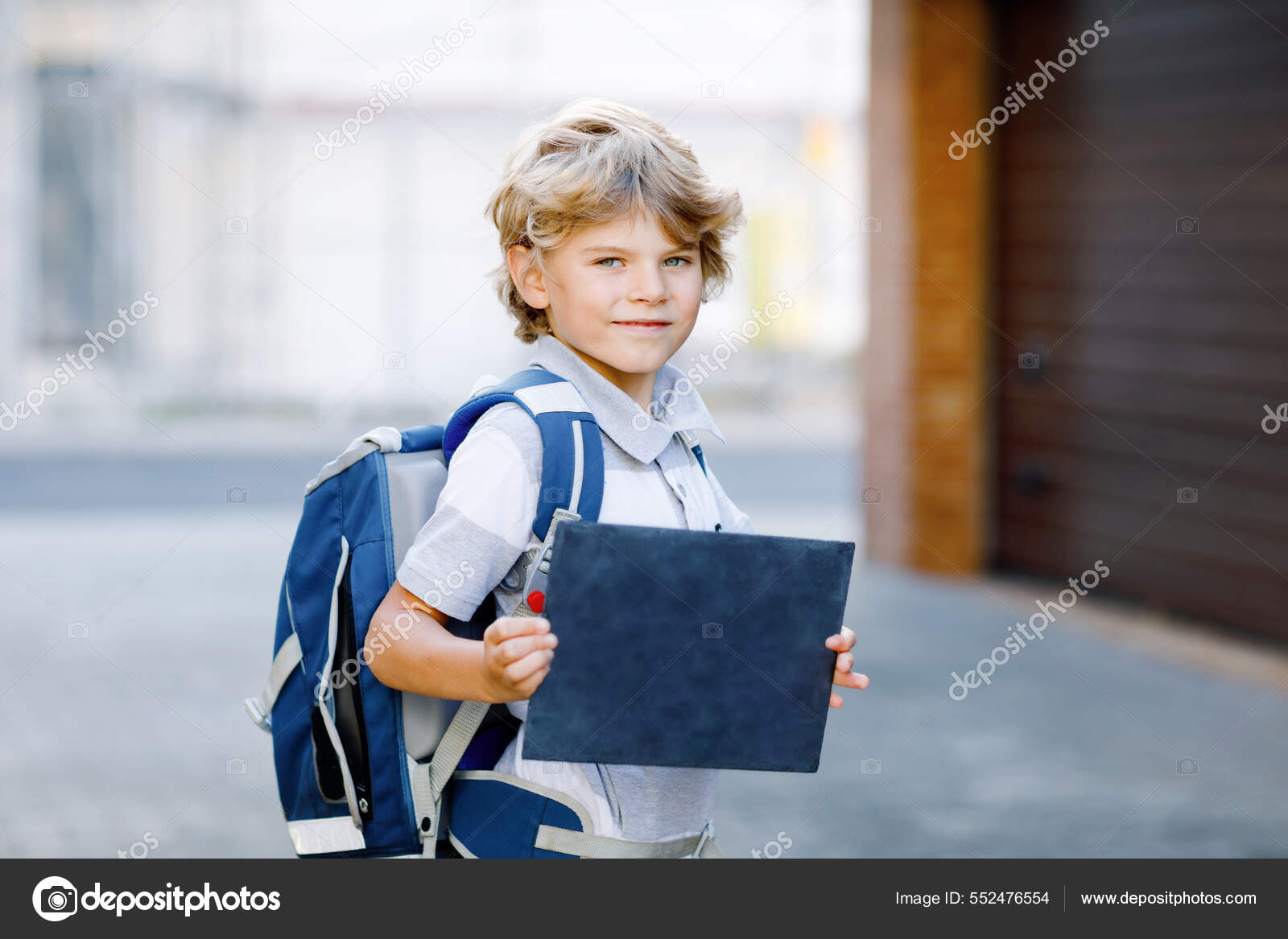 Joyeux petit garçon avec sac à dos ou sacoche appelé Ranzen en allemand. Un  écolier en