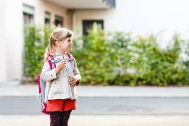 Anaokuluna giden tatlı küçük bir kız. Sağlıklı bir çocuk anaokuluna ve anaokuluna doğru yürüyor. Şehir caddesinde, açık havada sırt çantalı mutlu bir çocuk..