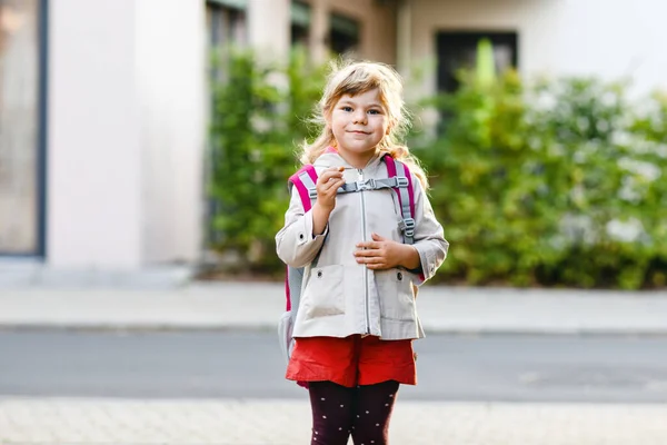 Menina pré-escolar bonito vai para a escola de brincar. Criança saudável caminhando para a creche e jardim de infância. Criança feliz com mochila na rua da cidade, ao ar livre. — Fotografia de Stock