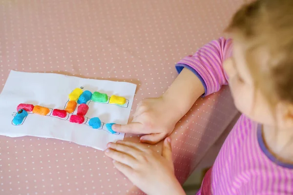 Klein creatief peutermeisje dat kleurrijke giraffe maakt met playmais. Actief gelukkig kind heeft plezier met tekenen doen handwerk. Onderwijs voor kinderen. Grappige activiteit. — Stockfoto