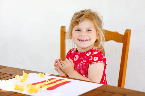Malá kreativní batole dívka malování s prstem barvy popcorn box a výrobu papírové kukuřice s lepidlem. Aktivní dítě se baví kreslením na řemeslo. Vzdělání pro děti. Vytvořit aktivitu. — Stock fotografie