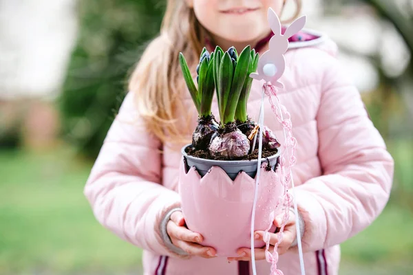 Primer plano de la niña adorable sosteniendo flores de jacinto rosa. Feliz niño, en el interior. Día de la madre, día de San Valentín o cumpleaños y concepto de primavera de Pascua. —  Fotos de Stock