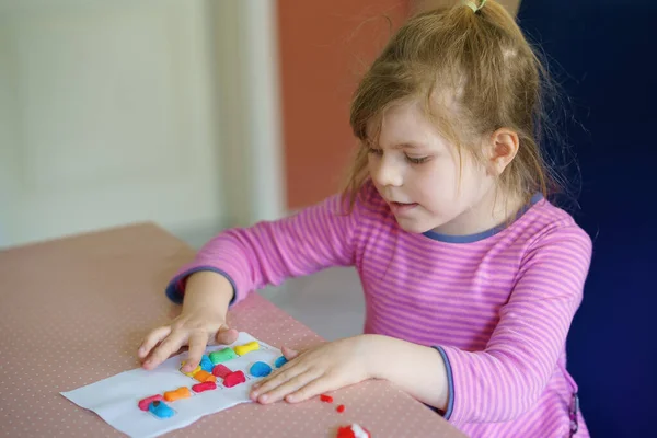 Piccola ragazza bambino creativo facendo giraffa colorata con playmais. Bambino felice attivo che si diverte con il disegno facendo artigianato. Educazione per bambini. Attività divertente. — Foto Stock