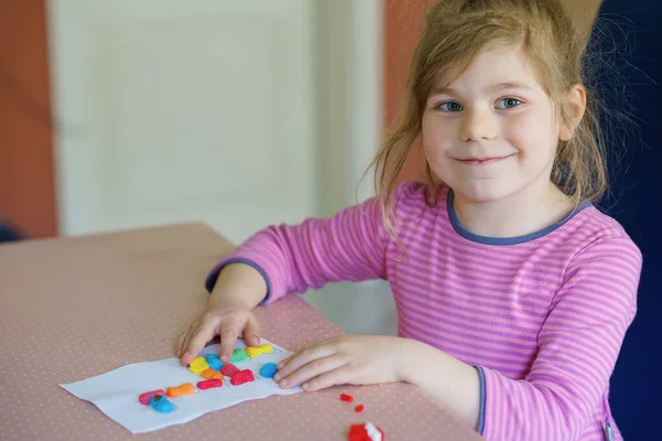 Mała kreatywna dziewczynka robi barwną żyrafę z playmais. Aktywne szczęśliwe dziecko bawiące się rysowaniem wykonując rzemiosło. Edukacja dla dzieci. Śmieszna aktywność. — Zdjęcie stockowe
