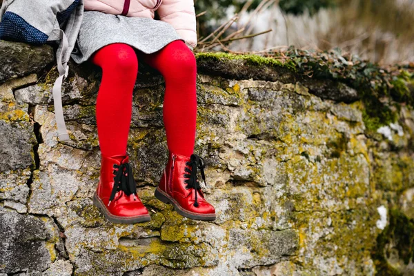 Menina de criança em sapatos vermelhos e meias-calças. Criança com mochila para creche ou escola infantil. Roupas e sapatos elegantes e bonitos para crianças. — Fotografia de Stock