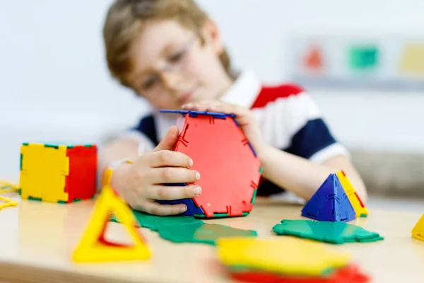 Happy kid jongen met bril veel plezier met het bouwen en maken van geometrische figuren, leren wiskunde en meetkunde — Stockfoto