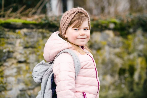 Portret van een vrolijk lachend peutermeisje buiten. Klein kind met blond haar, kijkend en lachend naar de camera. Gelukkig gezond kind genieten van buitenactiviteiten en spelen. — Stockfoto