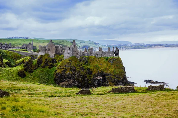 Dunluce Şatosu 'nun kalıntıları, Antrim, Kuzey İrlanda, güneşli bir günde yarı bulutlu gökyüzü. Vahşi Atlantik Yolu yakınlarındaki eski İrlanda kalesi. — Stok fotoğraf