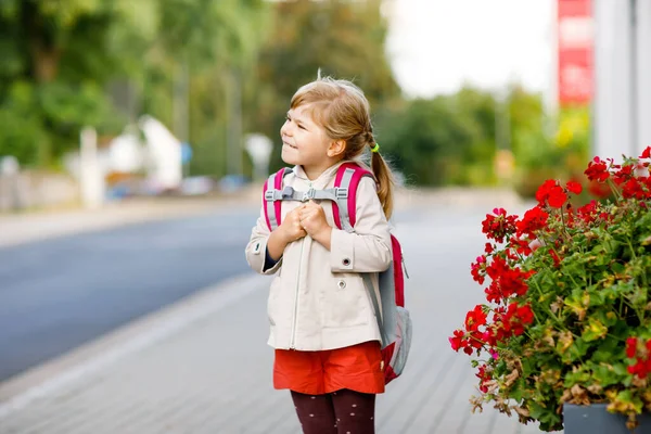 Linda niña preescolar yendo a la escuela de juegos. Niño sano caminando a la guardería y jardín de infantes. Niño feliz con mochila en la calle de la ciudad, al aire libre. —  Fotos de Stock