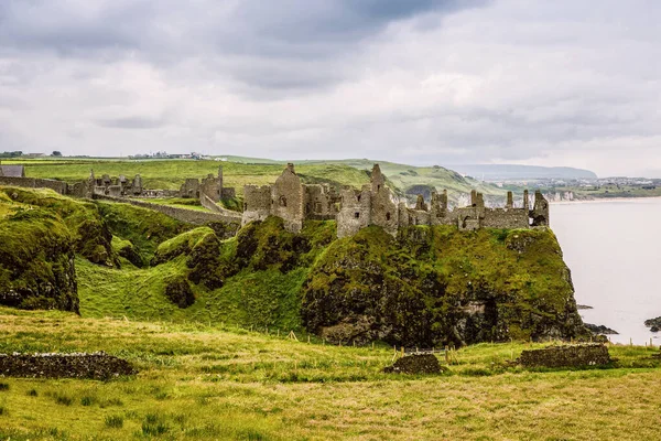 Dunluce Şatosu 'nun kalıntıları, Antrim, Kuzey İrlanda, güneşli bir günde yarı bulutlu gökyüzü. Vahşi Atlantik Yolu yakınlarındaki eski İrlanda kalesi. — Stok fotoğraf