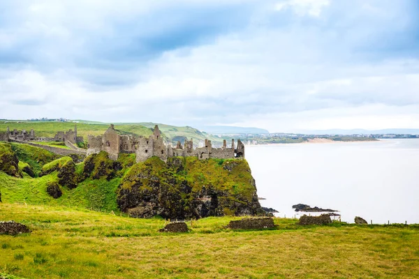 Ruiner av Dunluce Castle, Antrim, Nordirland under solig dag med semi molnig himmel. Irländska forntida slott nära Wild Atlantic Way. — Stockfoto