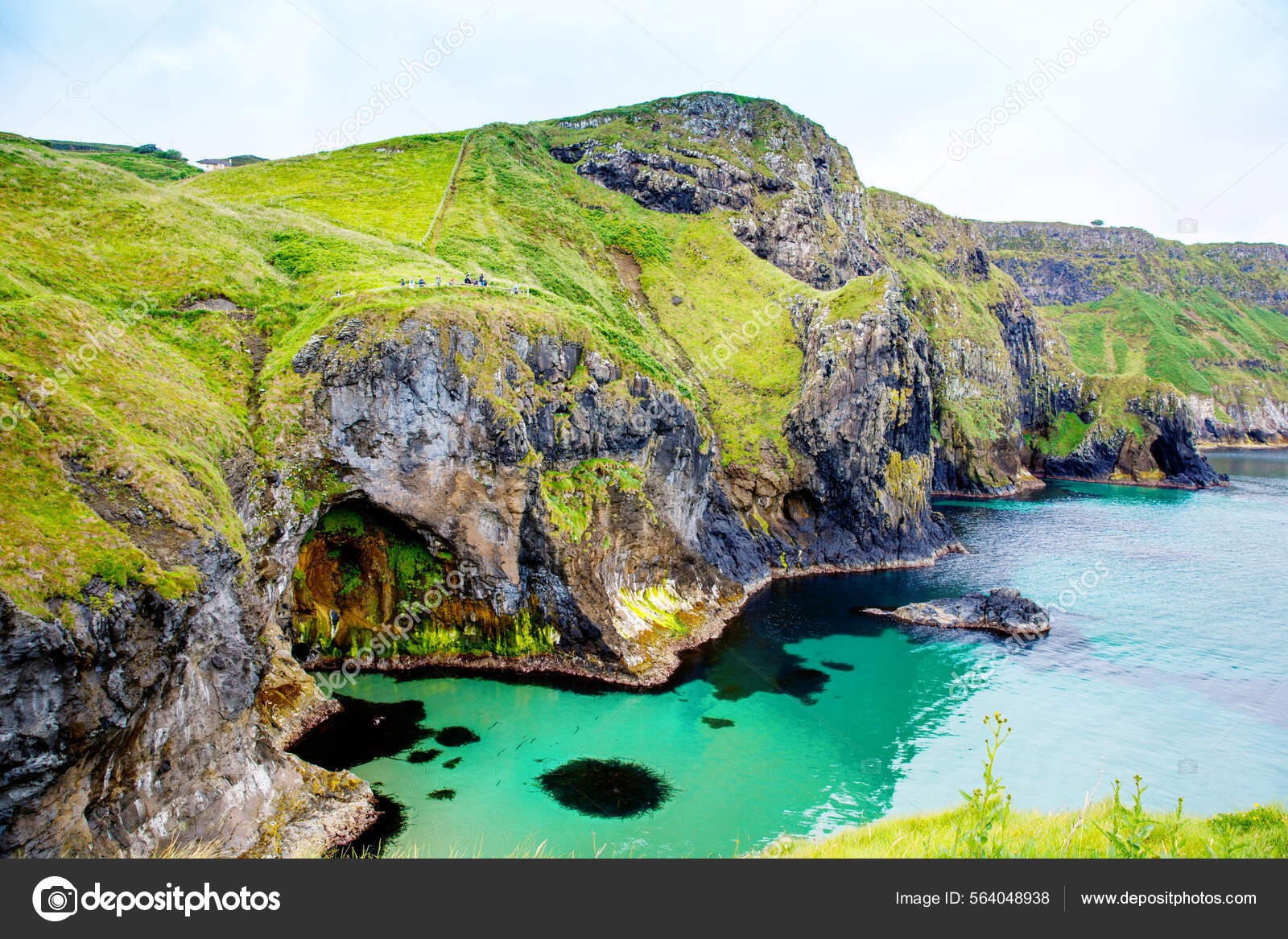 Coast near Carrick-a-Rede Rope Bridge, famous rope bridge near Ballintoy in  County Antrim, Northern Ireland on Irish coastline. Wild Atlantic Way on  cloudy day. Stock Photo by ©romrodinka 564048938