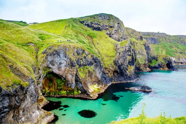 Carrick-a-Rede Köprüsü kıyısında, İrlanda kıyı şeridi üzerinde Kuzey İrlanda 'nın Antrim ilçesi Ballintoy yakınlarında meşhur ip köprüsü. Bulutlu bir günde Vahşi Atlantik Yolu.