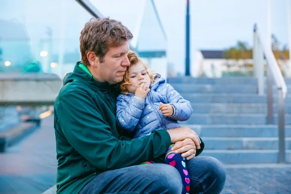 Beautiful portrait of cute little toddler girl with father. Happy baby child hugging with dad. Lovely family of man and daughter. Outdoors at the dusk. — Stock Photo, Image