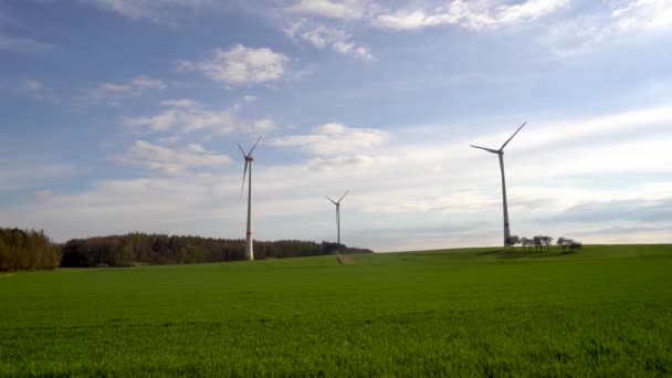 Panoramisch uitzicht op windpark of windpark op zonnige dag, met hoge windturbines voor de opwekking van elektriciteit met kopieerruimte. Concept groene energie. — Stockvideo