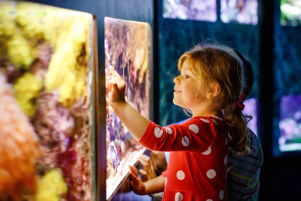 Carina bambina in visita all'acquario dello zoo. Bambino felice guardando pesci e meduse, coralli. Affascinato bambino con fauna selvatica di mare profondo. — Foto Stock