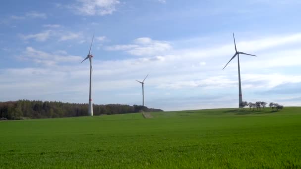 Panoramic view of wind farm or wind park on sunny day, with high wind turbines for generation electricity with copy space. Green energy concept. — Vídeo de Stock