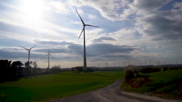Panoramic view of wind farm or wind park on sunny day, with high wind turbines for generation electricity with copy space. Green energy concept. ロイヤリティフリーのストック動画