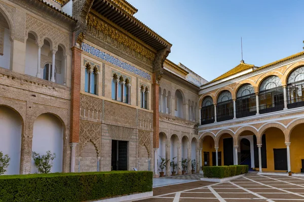 Byggnader av palatset Alcazar i Sevilla. Med vacker formell offentlig trädgård inne i Alcazar Sevilla palats på sommaren i Andalusien — Stockfoto