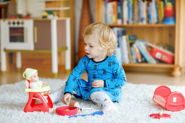 可爱可爱的小女孩在玩洋娃娃。快乐健康的孩子玩角色扮演游戏，在家里或托儿所玩妈妈游戏。玩具娃娃的活跃女儿. — 图库照片