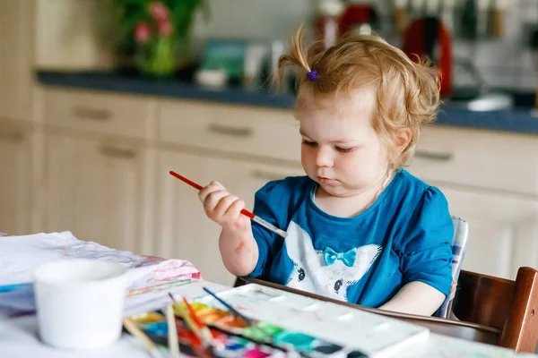 可爱的小女孩画与水彩画在纸上 幼儿学习不同的技能 创造性的闲暇和幼儿的活动 — 图库照片